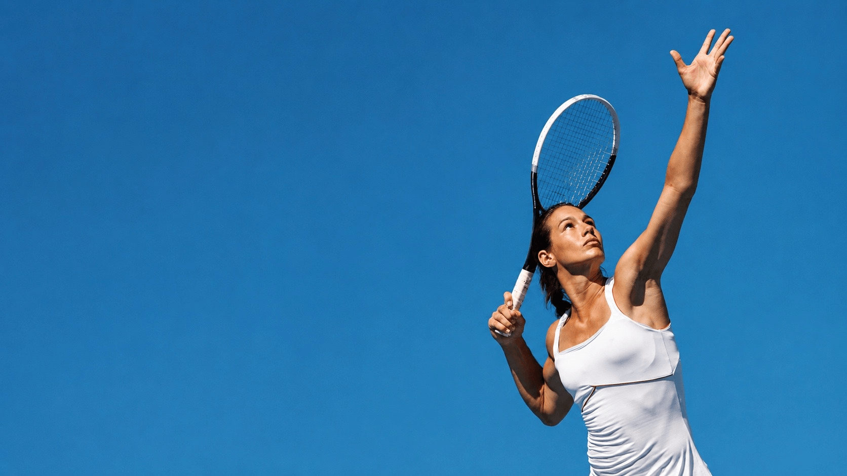 Athletic woman serving on a tennis court